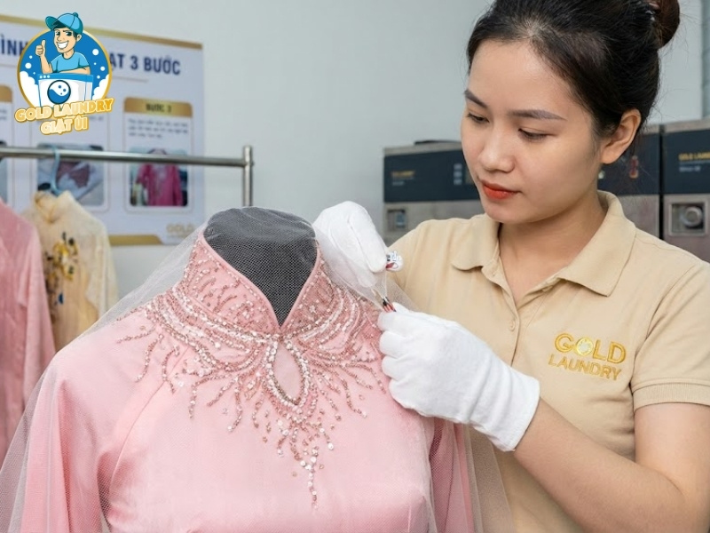 Nhân viên Gold Laundry đang bọc lưới bảo vệ phần hạt đính trên áo dài